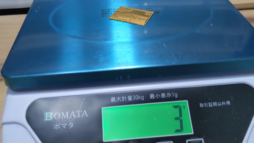 BOMATAスケールに金色の切手をのせて重さを軽量している様子、重さは3gだった